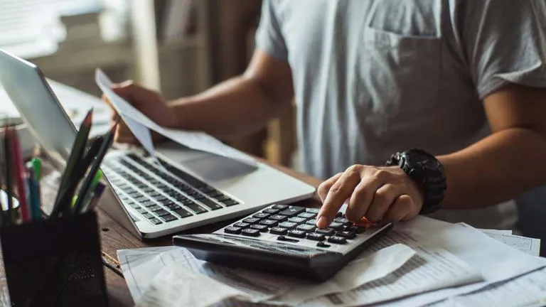 Liquidación tributaria Una persona realizando una suma impositiva